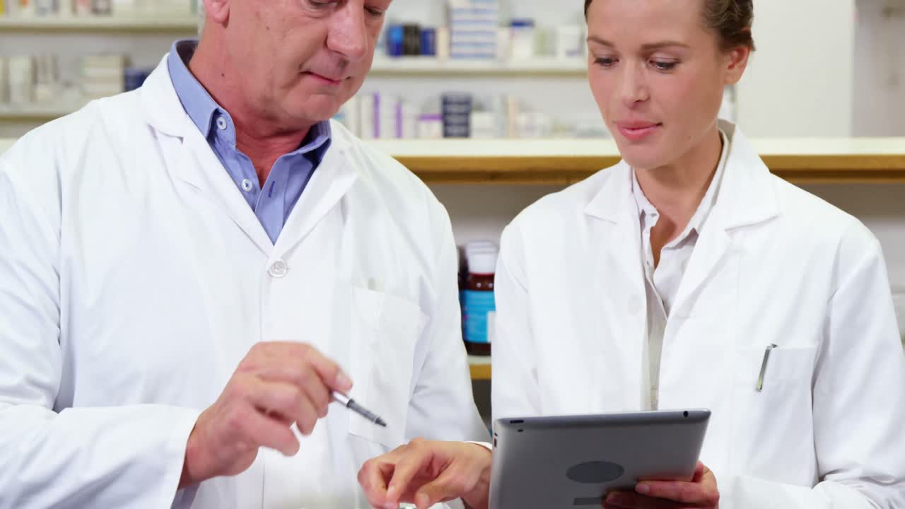 디지털 태블릿과 클립보드에서 토론하는 약사들