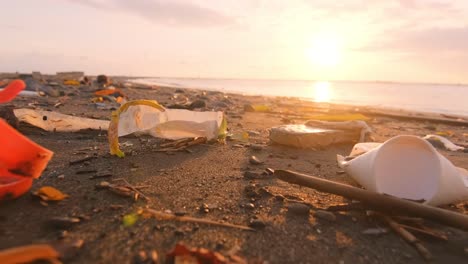 plastic waste on coastal sea sand non recyclable garbage thrown up by waves