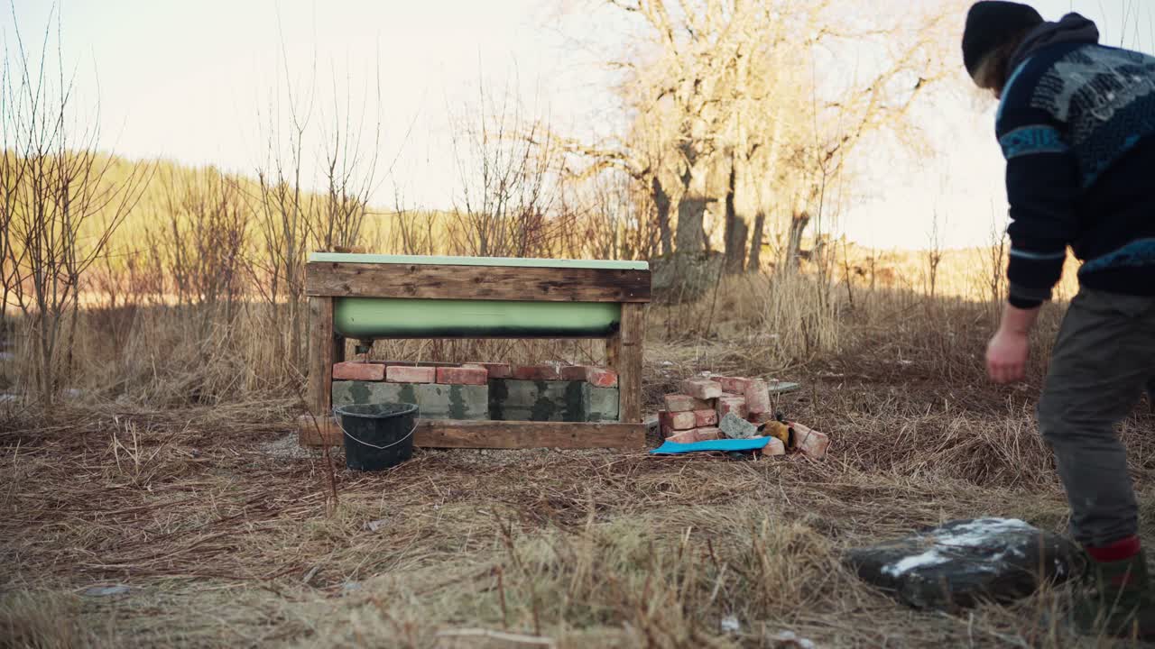 человек переносит плоский камень к горячей ванне - статический снимок