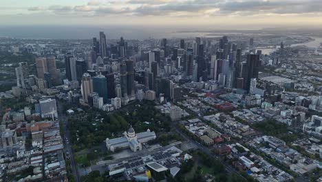 aerial view of melbourne city skyline with royal exhibition building and surrounding park at dusk