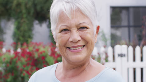 Portrait-of-happy-senior-caucasian-woman-looking-at-camera-in-garden