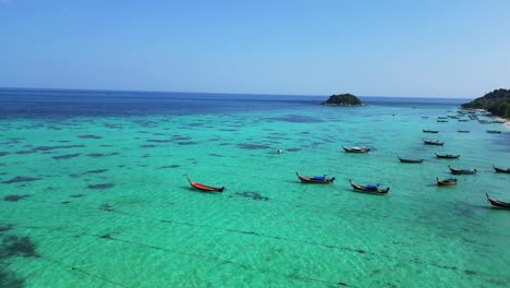 Longtail-Boot-Strand-Felsige-Klippe-Insel-Türkisblau-Meer