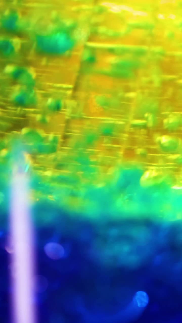 capas líquidas vibrantes que interactúan en un recipiente de vidrio