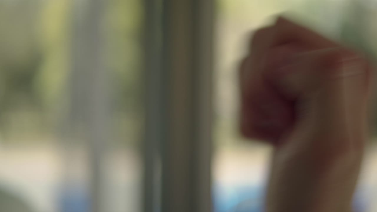 한 손이 유리 문에 손을 고 내부와 외부, 기대와 도착 사이의 경계를 흐리게합니다. 다른 쪽에서 무엇을 기다리고 있습니까?