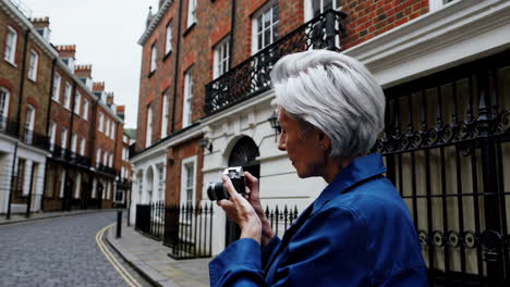 a senior photographer capturing moments with a vintage camera on a city street