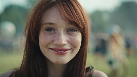 portrait of ginger haired smiling young caucasian woman at music festival