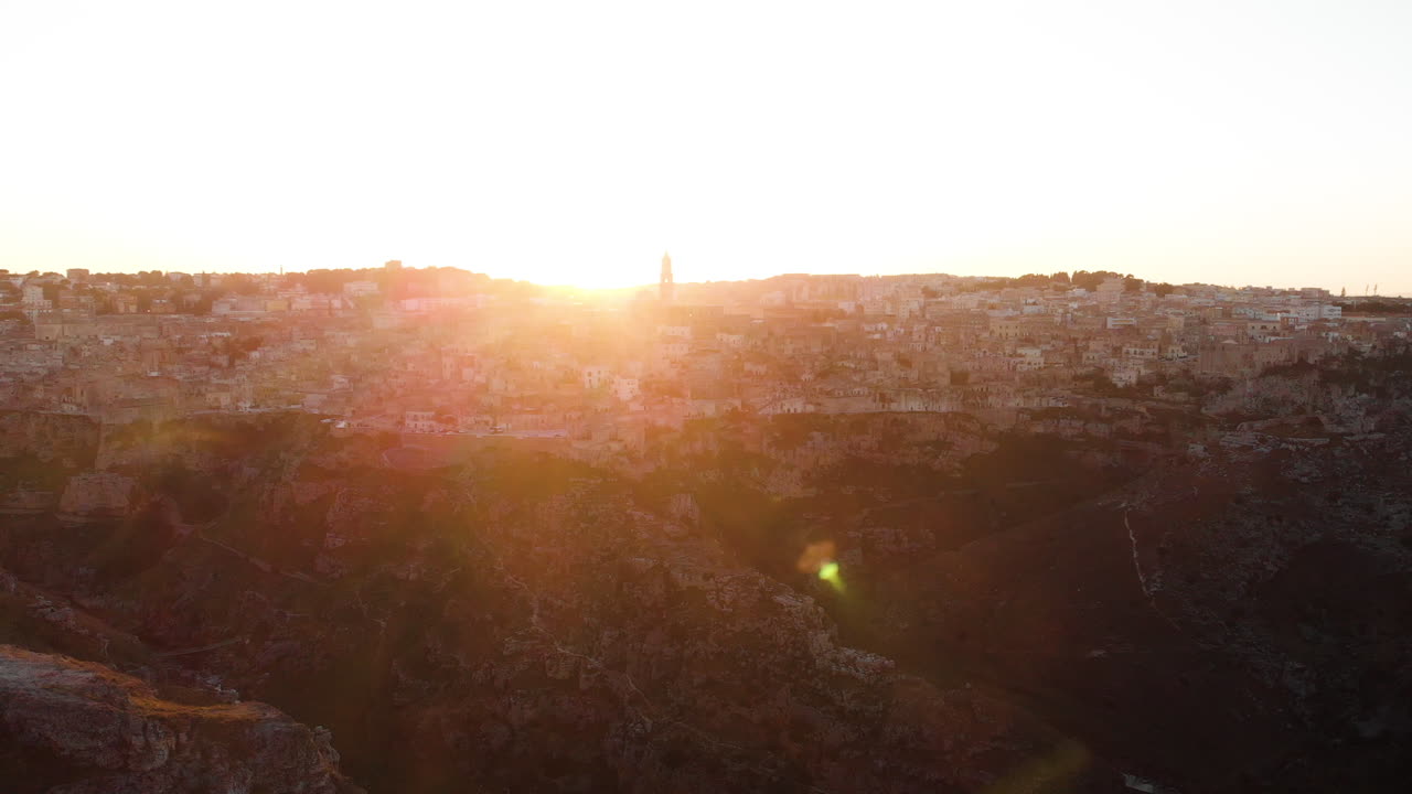 The fiery sunset behind the quiet city of Matera, Italy - aerial