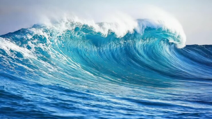 Dynamic video still of a powerful ocean wave, captured from a low angle, showcasing vibrant blue