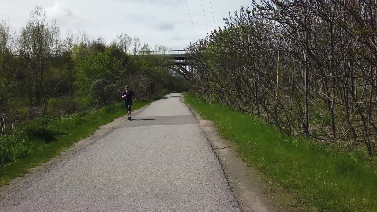 Cycling point of view on Don Valley trail, with approaching jogger, and bridge in the distance