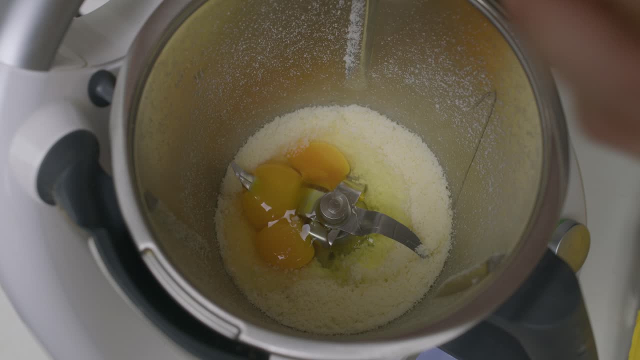 agregar huevos al queso triturado dentro de la mezcladora