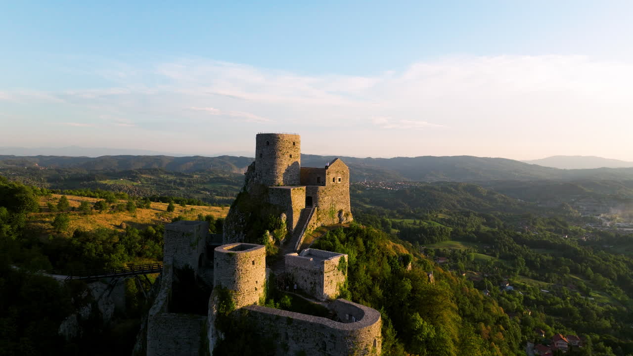 Male Traveler Sitting On Srebrenik Castle With Scenic Sunset Overview In Tuzla, Bosnia and Herzegovina. drone pullback reveal