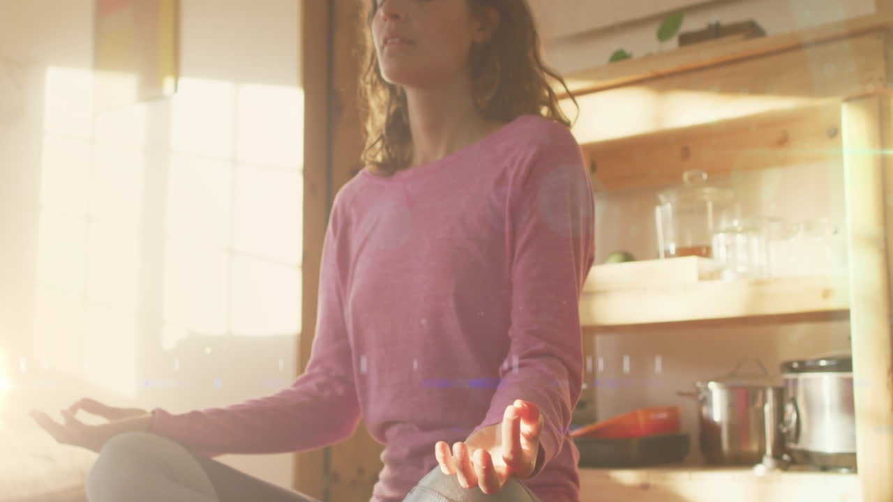 animación de puntos de luz sobre una mujer caucásica practicando yoga y meditando