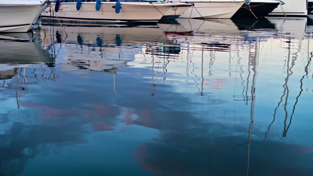 Reflection on the sea of white boats docked in the Port Vauban at sunset in Antibes, France