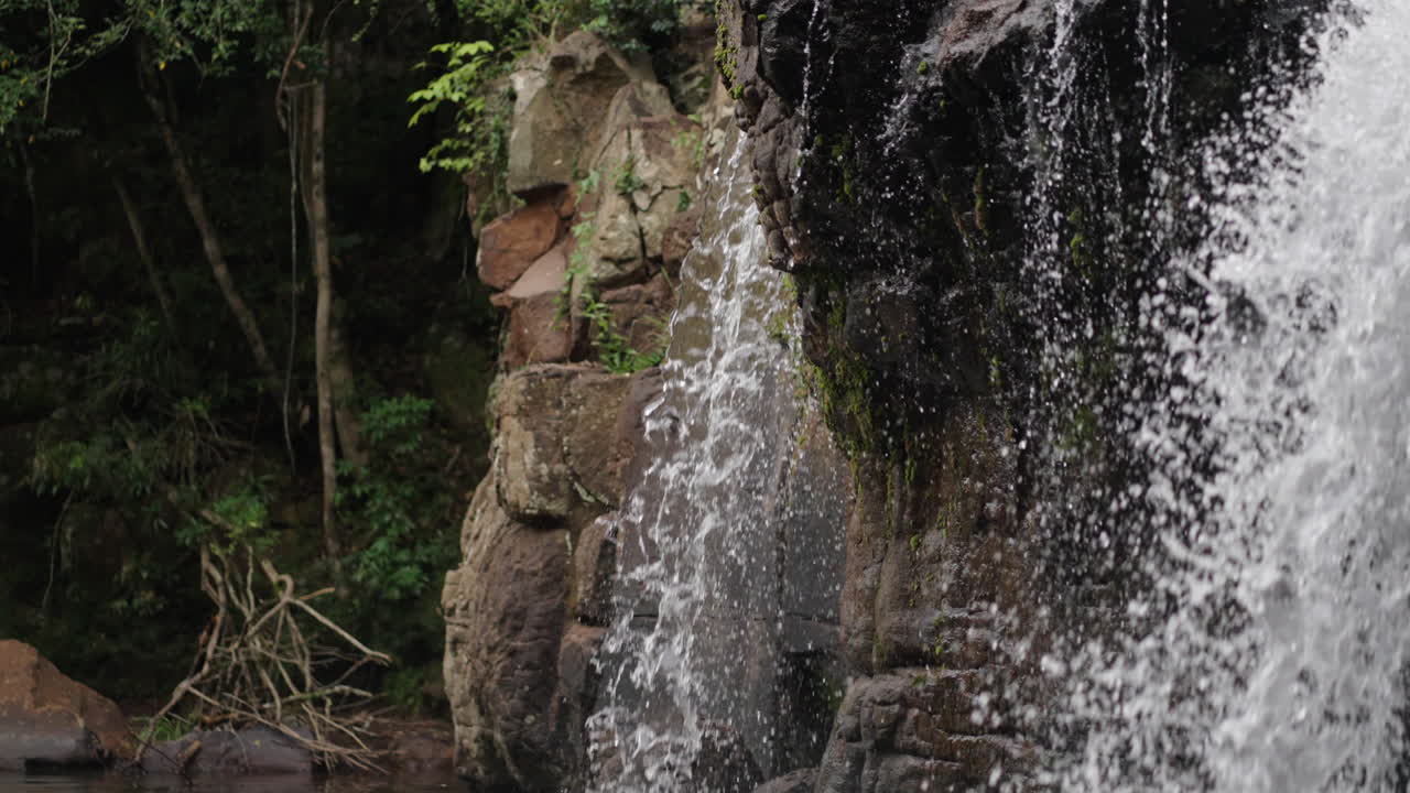 Close up waterfall lush strong water falling into a subtropical rock stone water landscape at Misiones Highs, Salto El Yerba, El Soberbio, Argentina