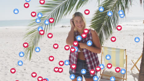 animation of red heart love and like digital icons over smiling woman on beach