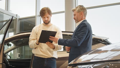 car dealership customer signing papers