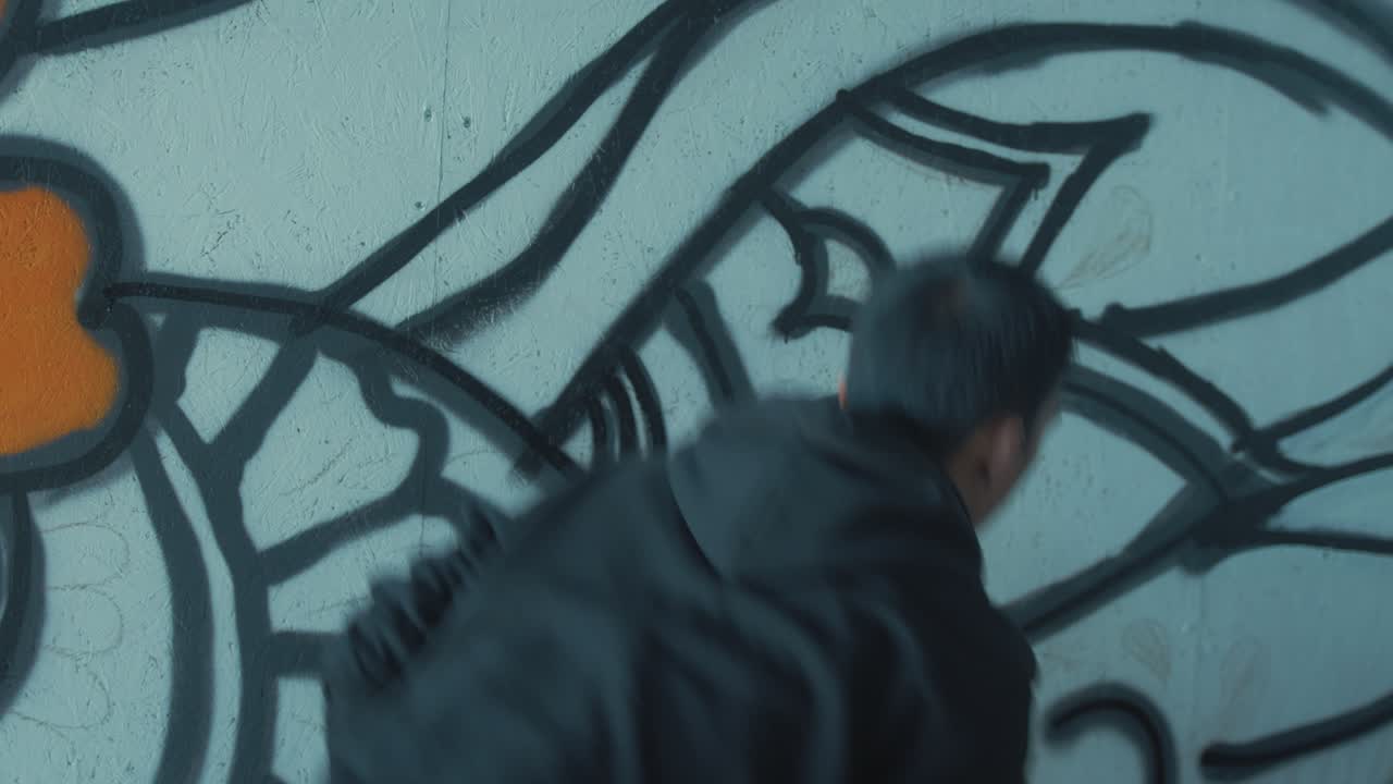 Graffitikunstner rister sprayboks og forbereder seg på å male veggen