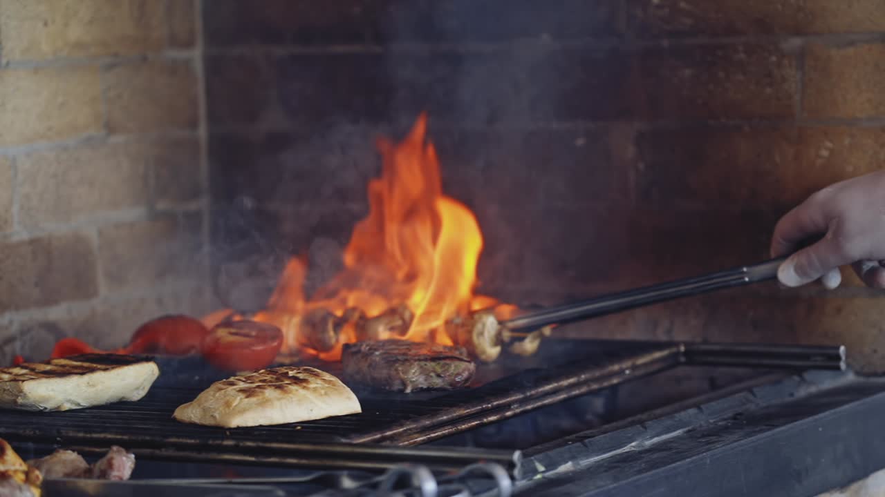 Cooking food in fire. Delicious meal on grid preparation by chef. Vegetables on grill. Bright flame during the cooking dishes.