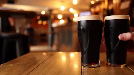 two pints of stout on a pub table