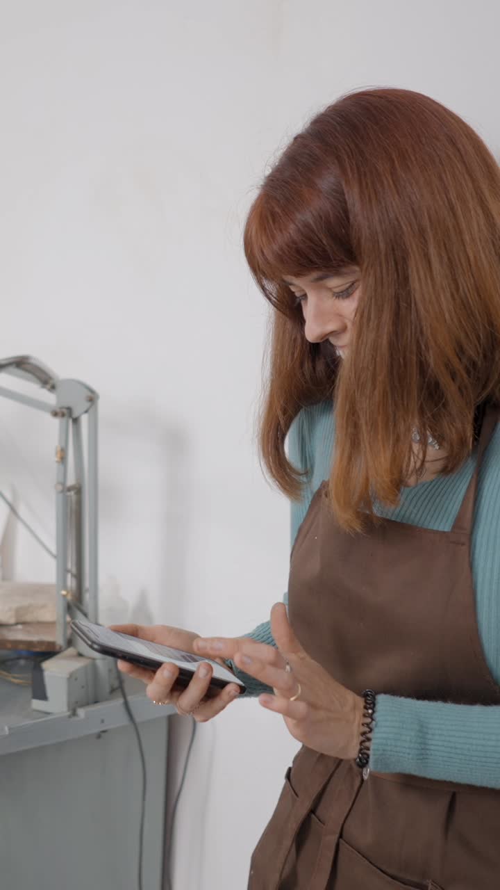 Woman in an apron using a smartphone