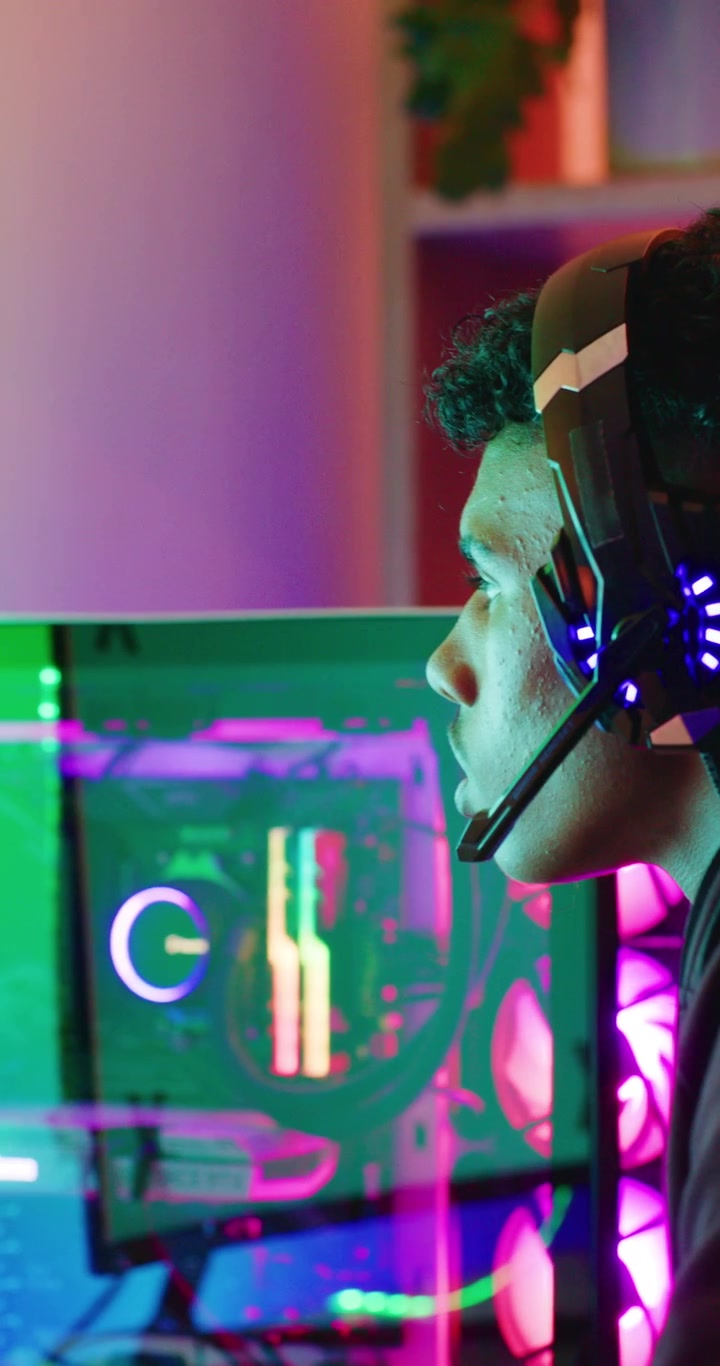 Young Gamer Wearing Headset Playing Video Game on PC