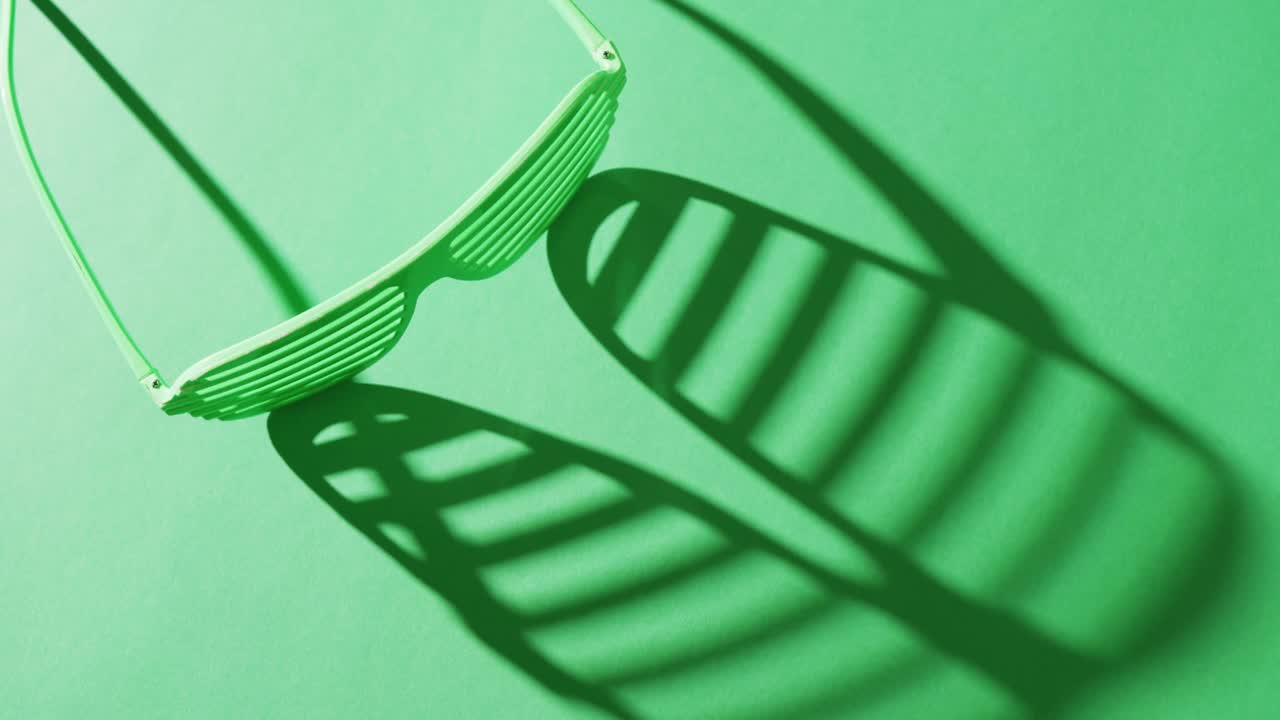 Video of st patrick's green glasses with copy space on green background