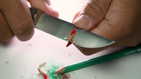 Footage-of-hands-slowly-sharpening-a-pencil-and-some-coloured-pencils-with-a-sharp-knife