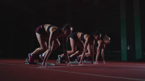 female athletes warming up at running track before a race. in slow motion