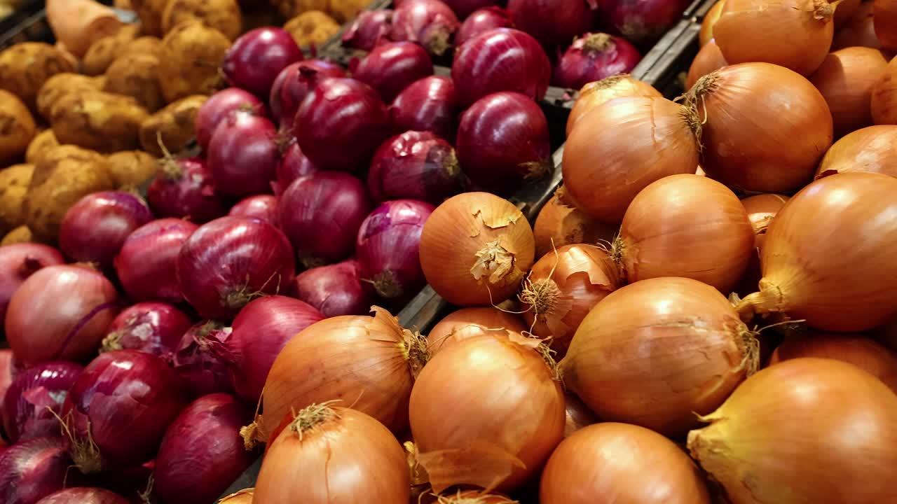 cebollas y patatas expuestas en los puestos del mercado