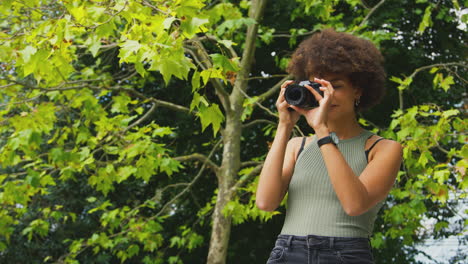 Mujer-Al-Aire-Libre-Con-Cámara-DSLR-Tomando-Fotos-En-El-Parque-De-La-Ciudad-En-Verano