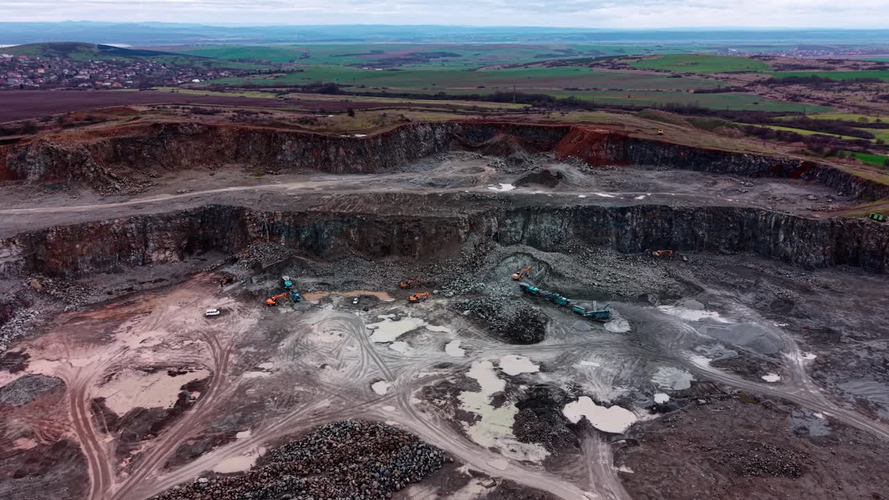 Heavy machinery works in a large quarry where granite is extracted