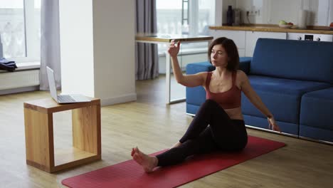 Una-Mujer-Demostró-La-Postura-De-Yoga-Ardha-Matsyendrasana-Con-Medio-Giro-Mientras-Miraba-El-Tutorial