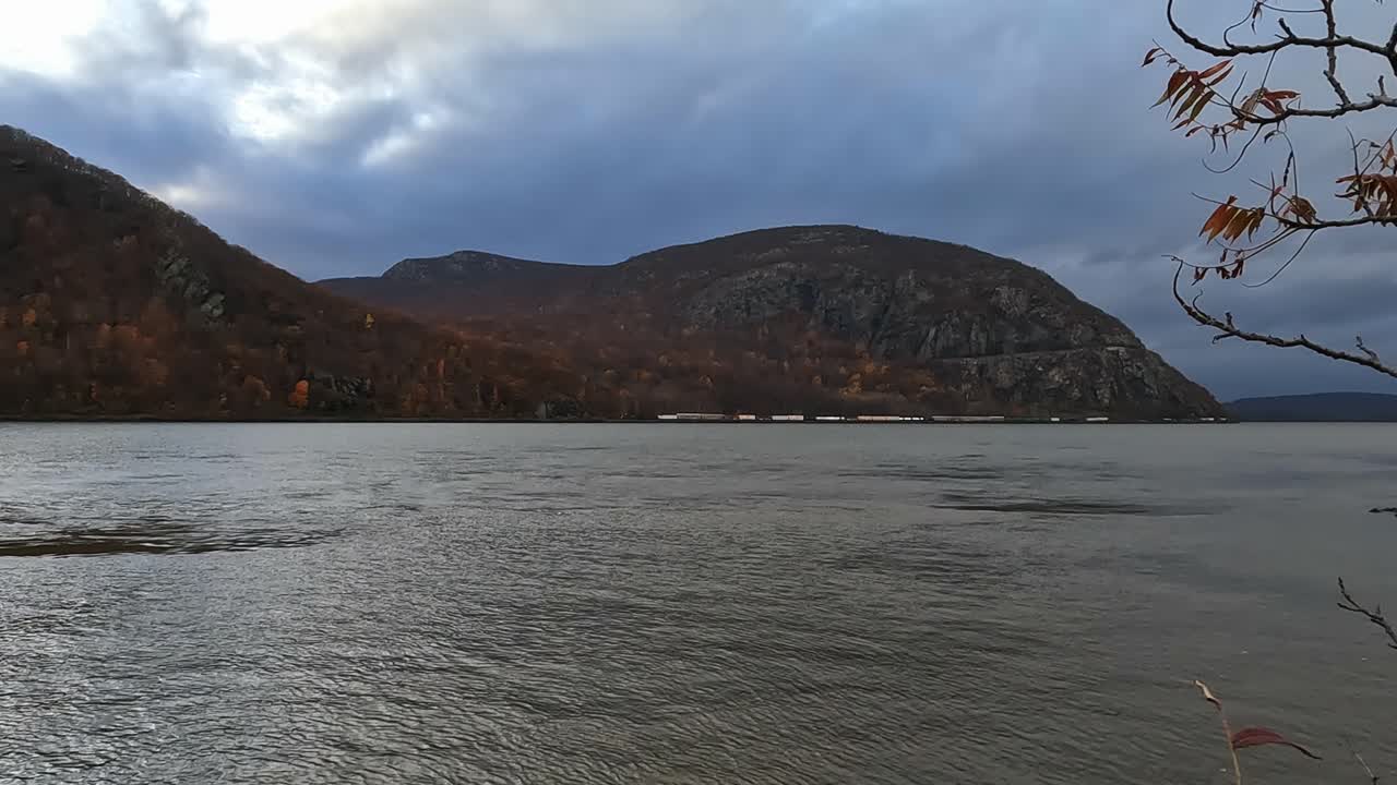 A freight train traveling down the Hudson River in New York's Hudson Valley during fall