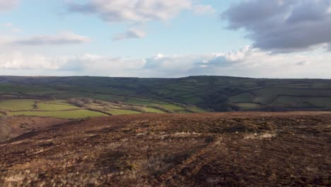 toma panorámica aérea de la puesta de sol sobre exmoor uk con campos verdes y cielo azul