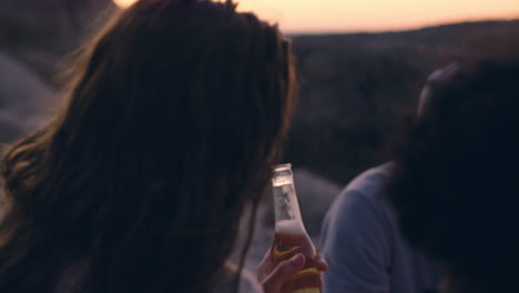 Beach-bonfire-with-group-of-friends,-drinking-beer-and-playing-guitar