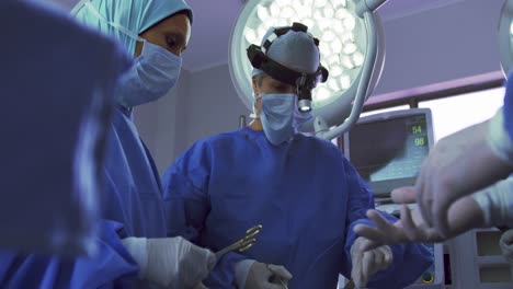 vista de ángulo bajo de una cirujana de oriente medio realizando una cirugía en el teatro de operaciones de un hospital