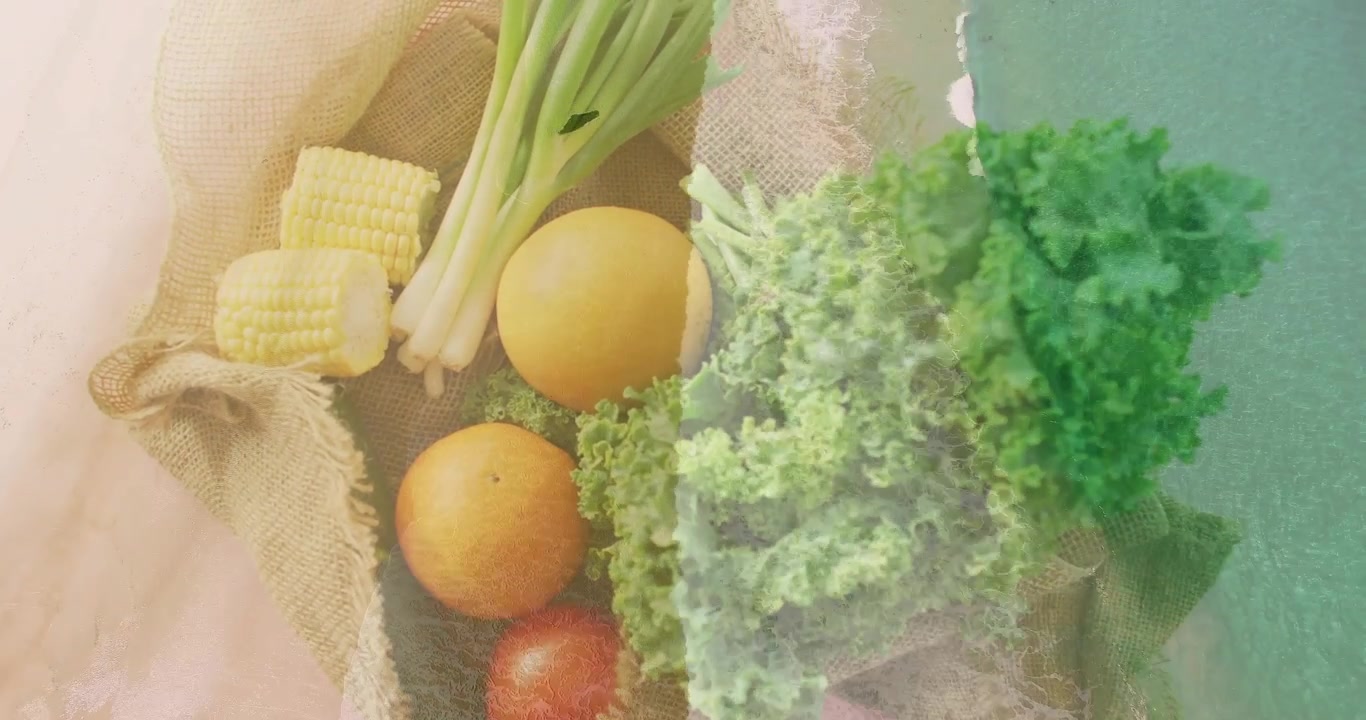 Vassoio di iuta che rivela prodotti agricoli, mostrando una sovrapposizione di cavolo riccio e mais, con texture che si alleggeriscono e si riscaldano per uso culinario.