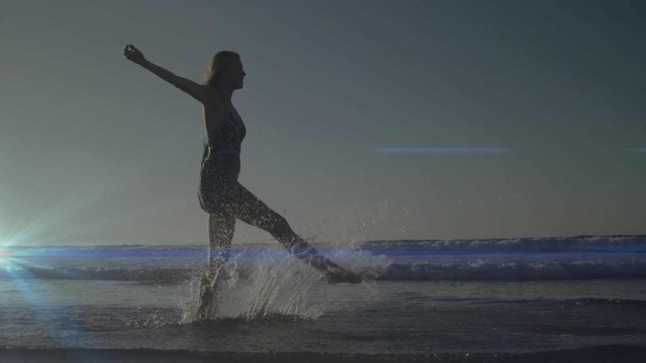 Stepping into shallow ocean water woman performing rhythmic leg lifts and kicking water for travel