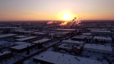 drone shot of a steaming factory during sunset