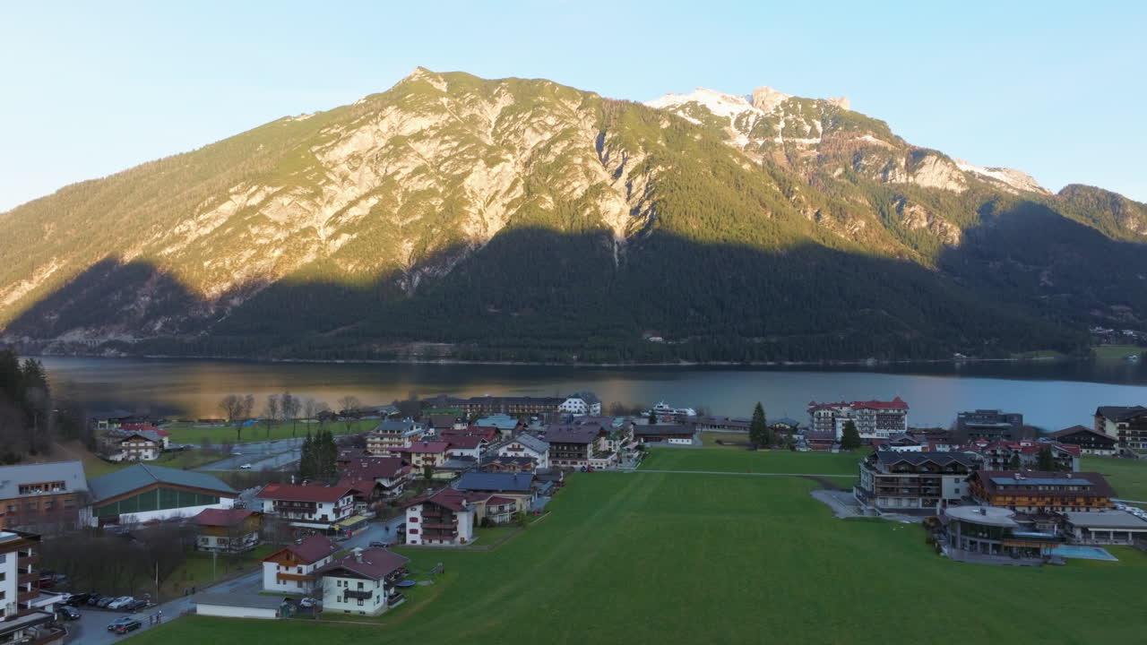 오스트리아 티롤에서 일몰 동안 아름다운 아첸제 호수 기슭에 있는 페르티사우 마을 - 공중 드론 샷