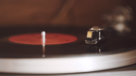 an old, dusty record player is playing a black vinyl record with a red label at 33 1-3 rpm