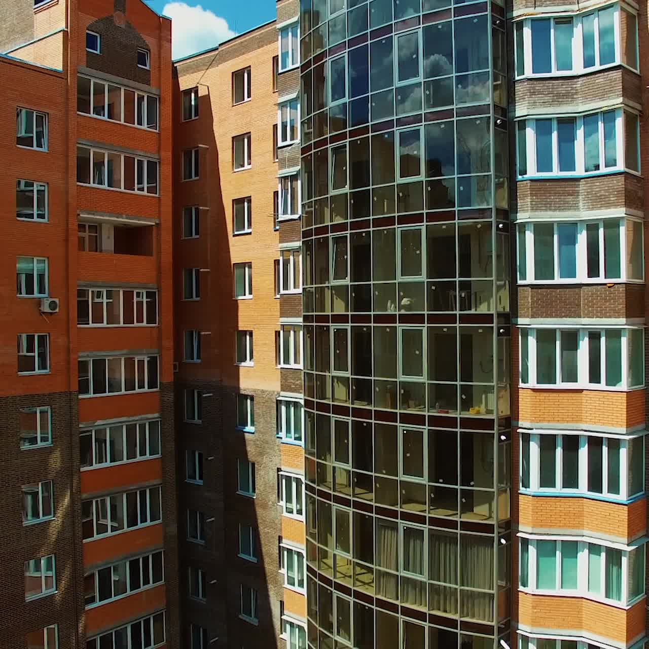 Architecture of urban background. New high-rise buildings with many windows and modern balconies. Tall apartments in the city.