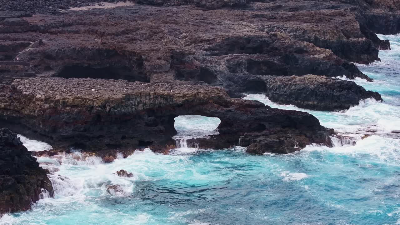 엘 히에로 해안을 따라 화산 아치, 생생한 푸른 물에서 물결이 부히고