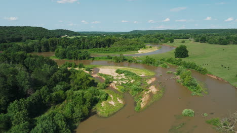 illinois river flowing through lush vegetation in arkansas, usa - aerial drone shot