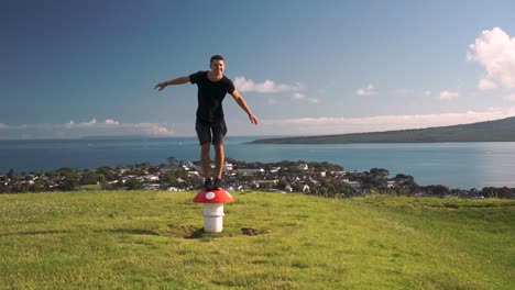 slowmo - young caucasian tourist standing on metal mushroom sculpture vent on mount victoria, auckland, new zealand