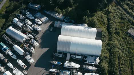 aerial fly over aquatic storage yard for various boats fishing deck dinghy bowrider catamaran cuddy cabin center console house boats trawlers yachts cabin cruisers while some are getting repaired 1-2