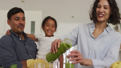 Happy-hispanic-family-with-daughter-having-green-smoothie