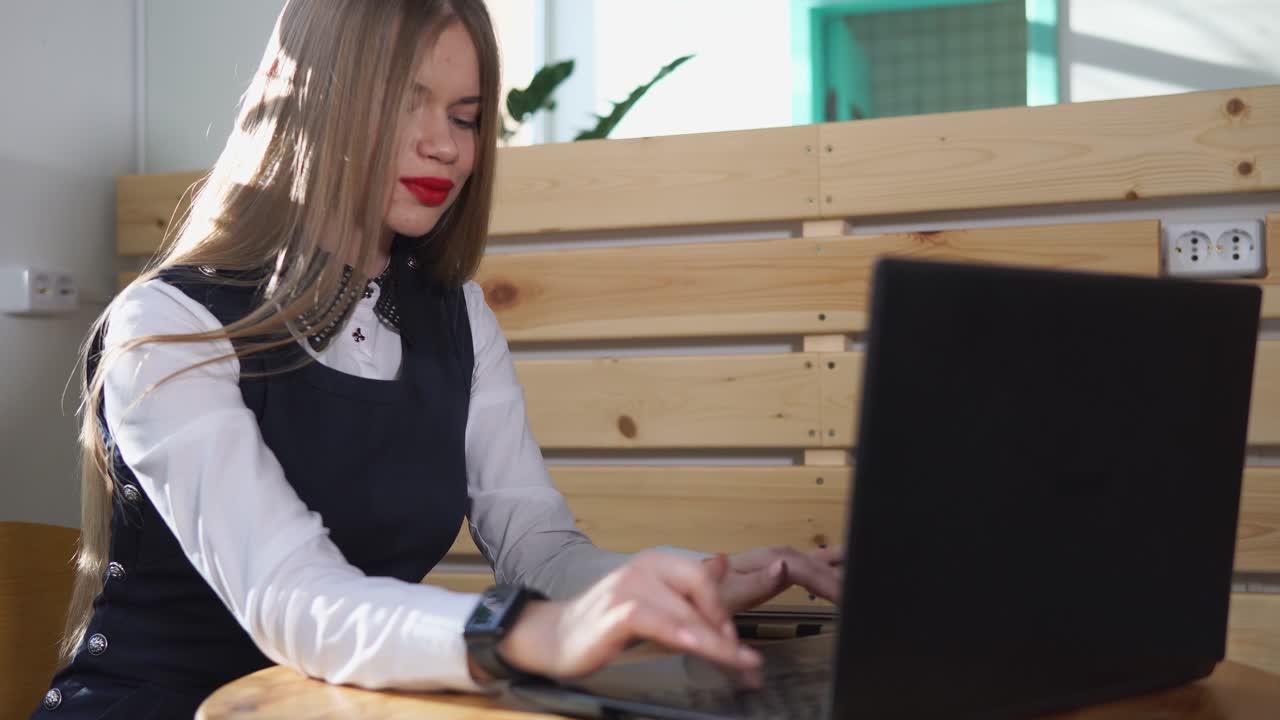 Giovane donna che lavora al portatile in un caffè