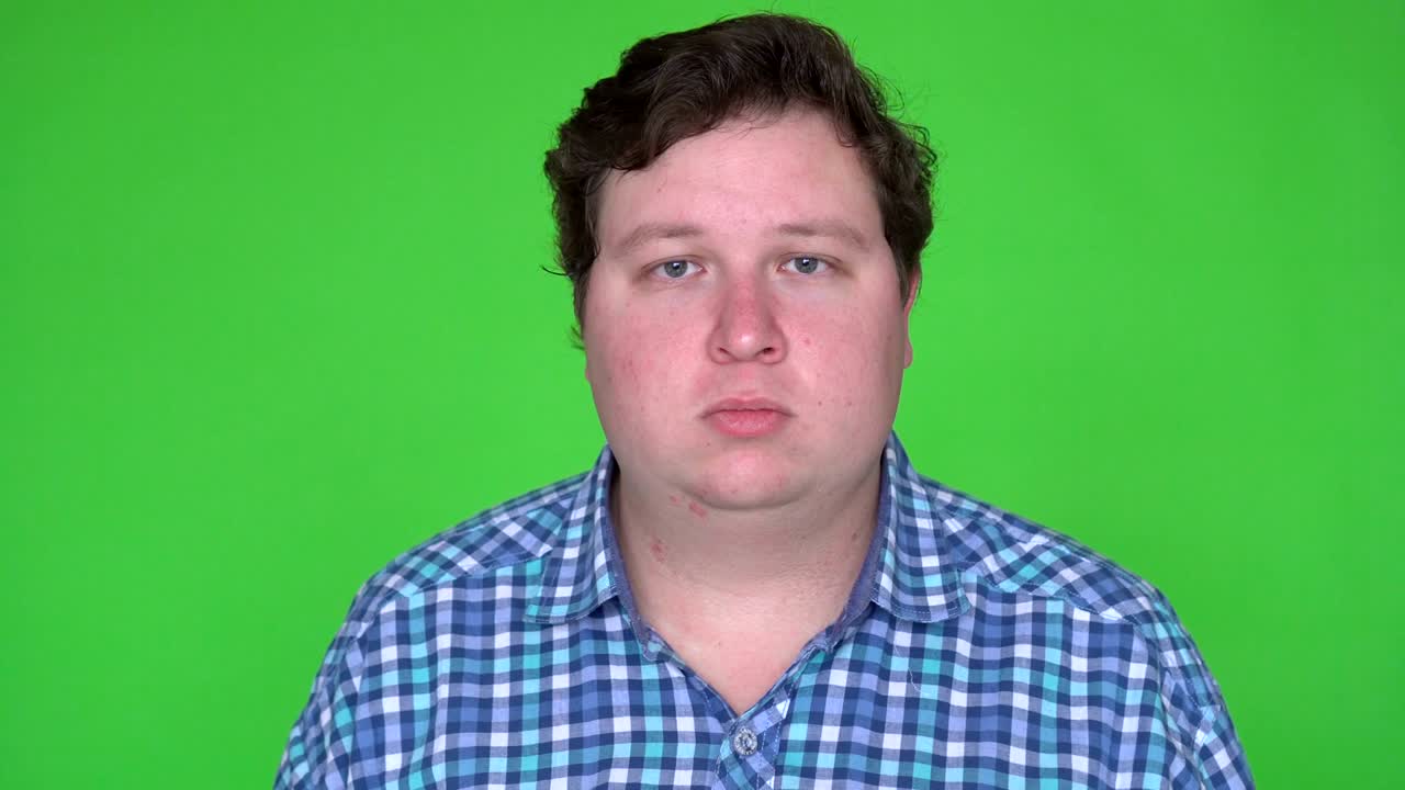 Portrait of caucasian man with plaid shirt looking at camera with blank expression. Chroma keying.