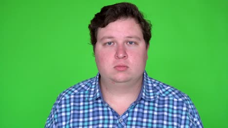portrait of caucasian man with plaid shirt looking at camera with blank expression. chroma keying.